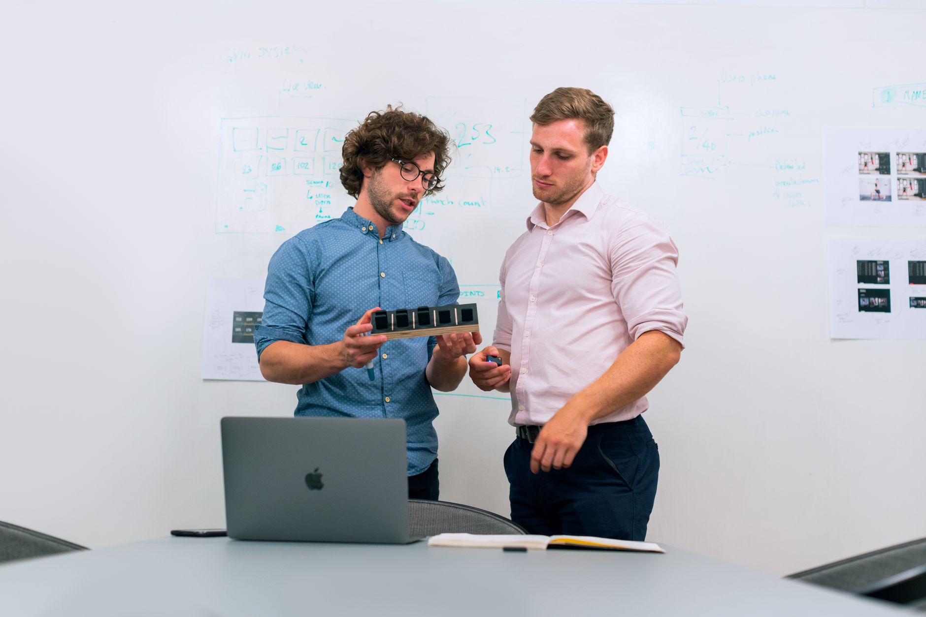 Two engineers in an office reviewing a pull request together