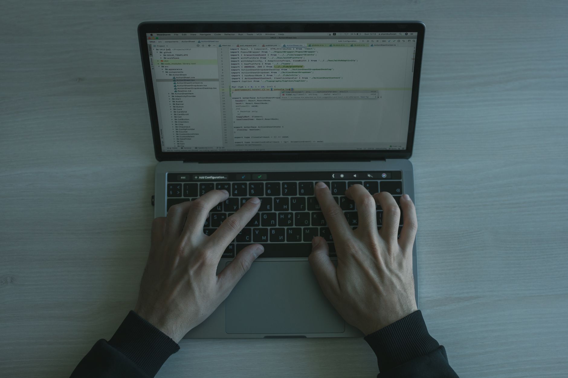 Close-up of hands typing on a laptop keyboard in a coding session