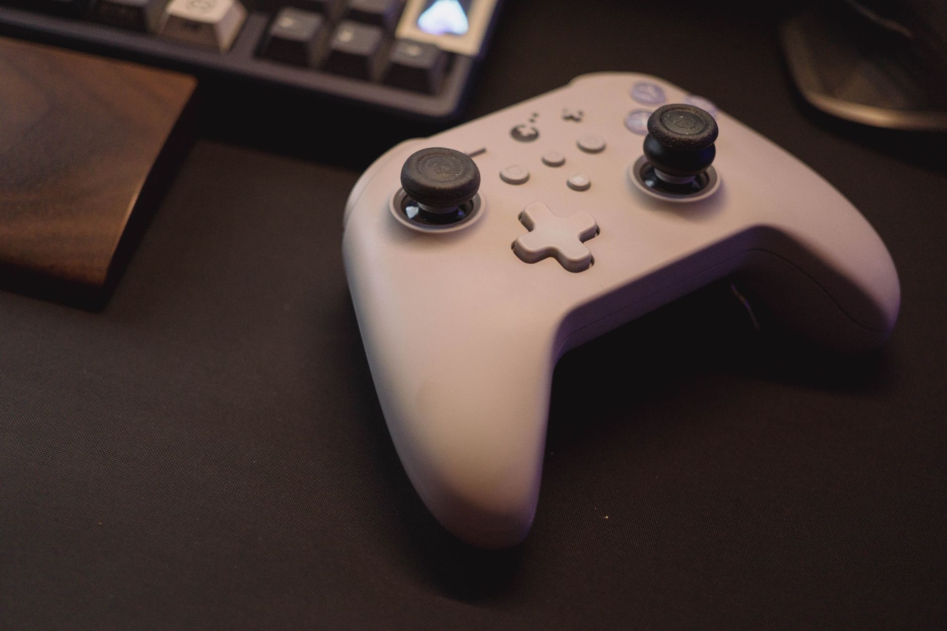 White gaming controller on a black desk setup